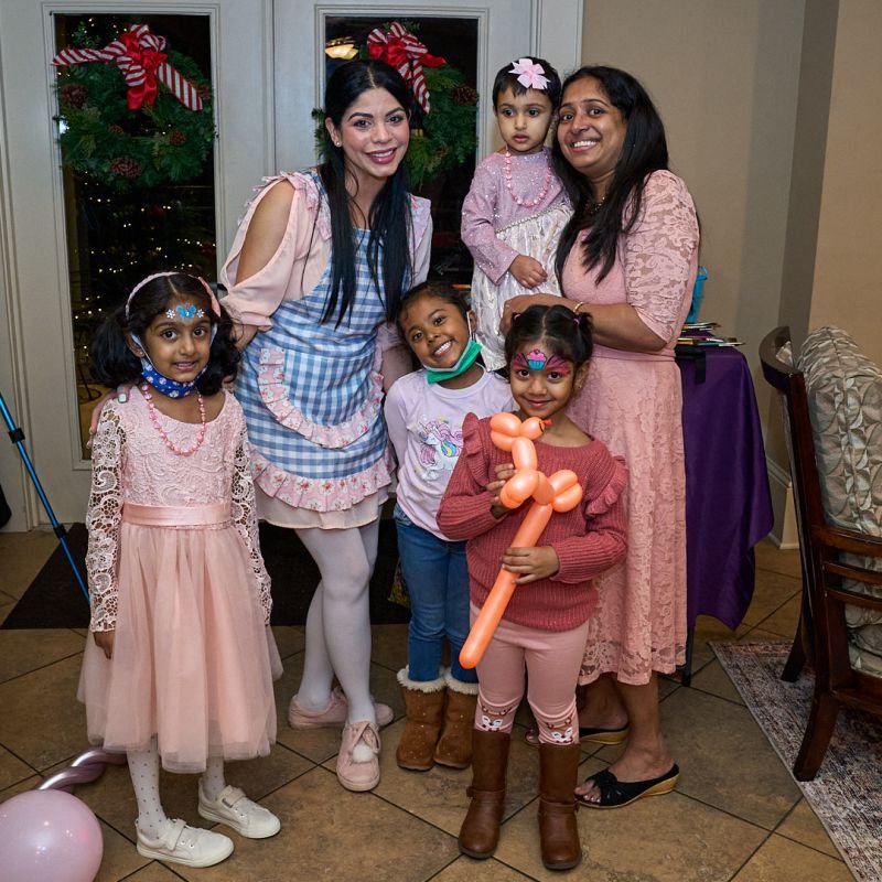 Alby Bello with a family and their face-painted kids at a holiday celebration