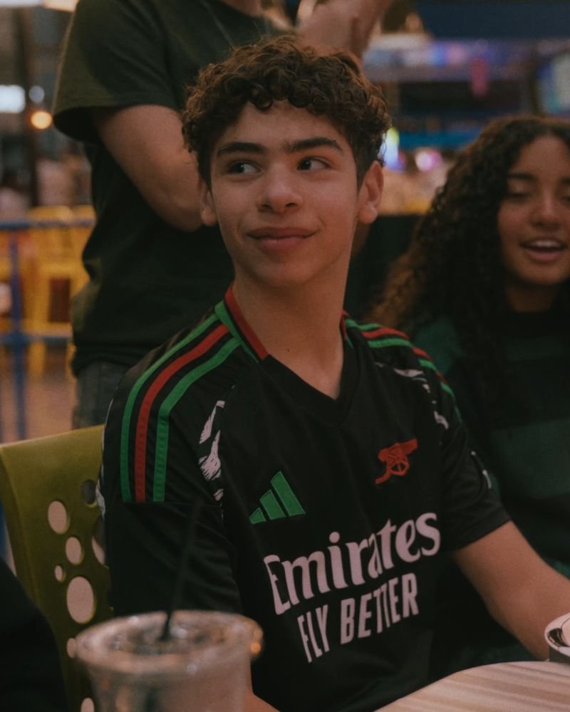 A birthday boy smiling beside his candle-lit cupcake, a still from our highlight film