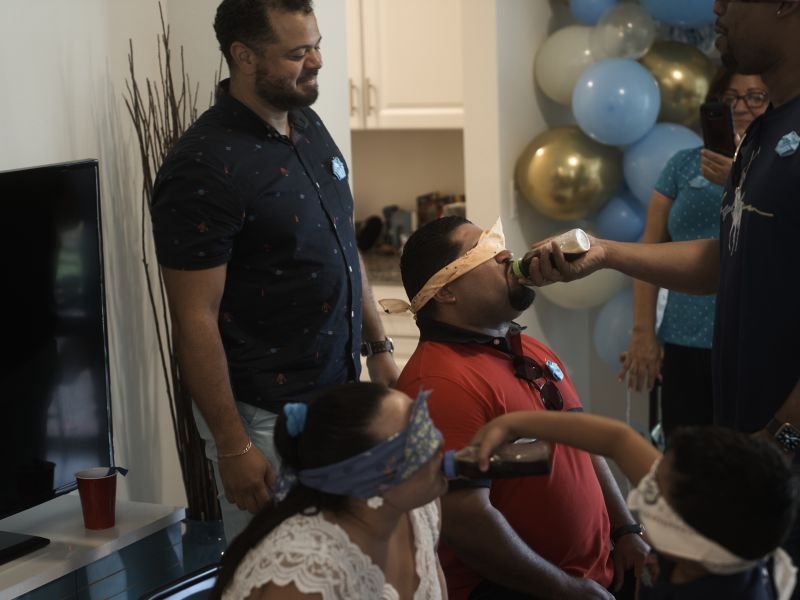 Blindfolded guests laughing through a baby shower game