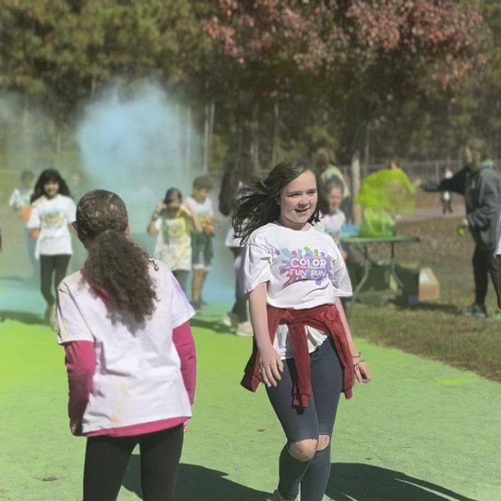 Kids in color run shirts walking a powder-covered path