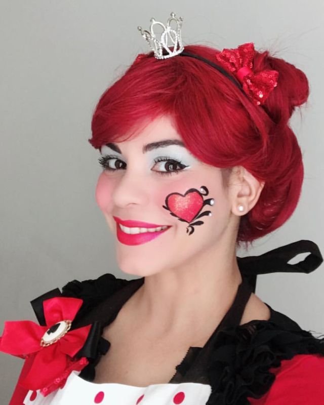 Alby Bello dressed as the Queen of Hearts with a painted heart on her cheek
