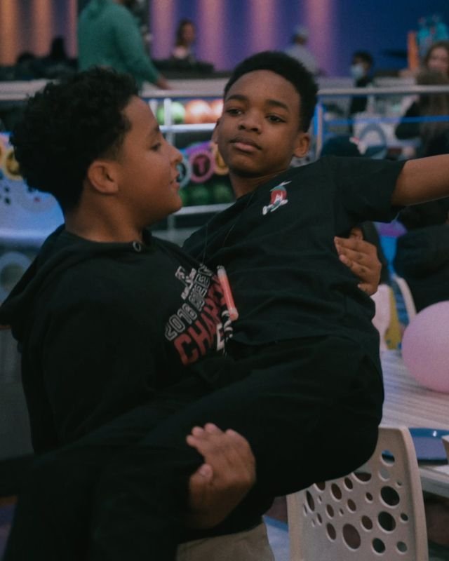 Two friends goofing around at a birthday party